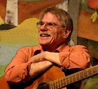 photo of Gordon Bok smiling and seated with his guitar on his lap