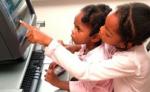 two young children using a computer