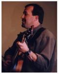 photo of Todd Werner in concert, singing and playing the guitar