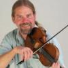 photo of Kevin McMullin playing fiddle and smiling