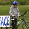 photo of a boy on his bike next to a sign that reads "Peace"