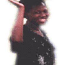 photo of African woman smiling and carrying a tray on her head