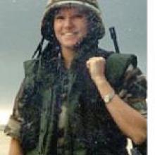 photo of Chante Wolf in her miliatry uniform and carrying a rifle