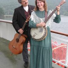 photo of Dave Para holding a guitar, and Cathy Barton holding a banjo