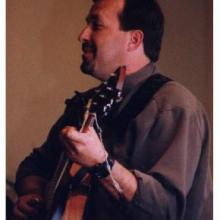 photo of Todd Werner in concert, singing and playing the guitar